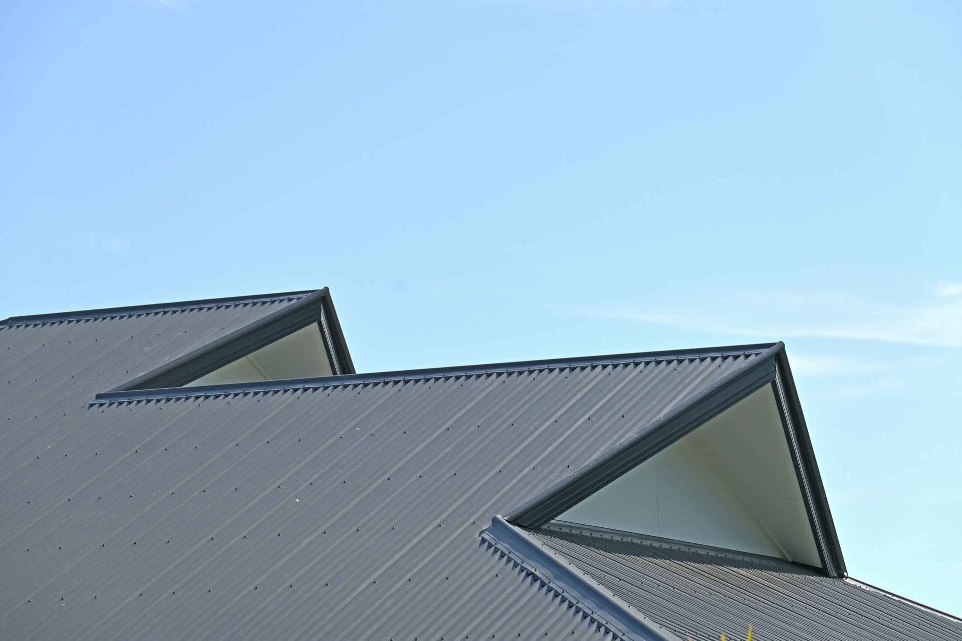A close up of a roof with a blue sky in the background