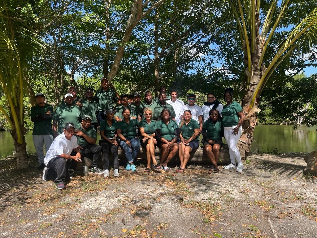 A group of people are posing for a picture under a tree.