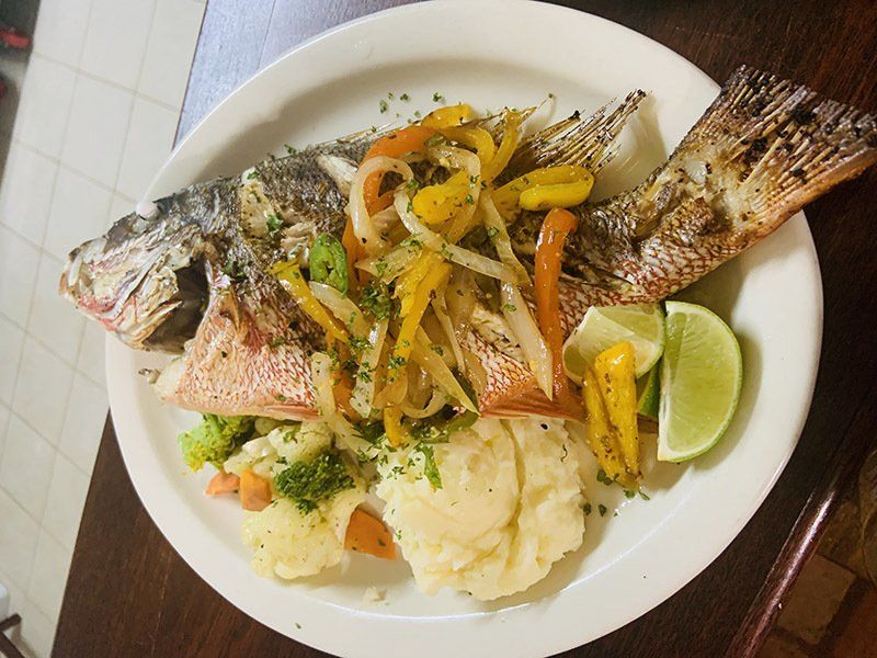 A plate of food with a fish and vegetables on it