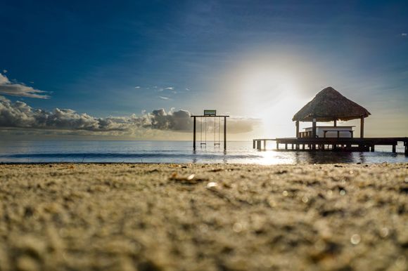 A beach with a dock and a hut on it.