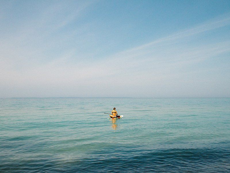 A person is paddling a kayak in the ocean.