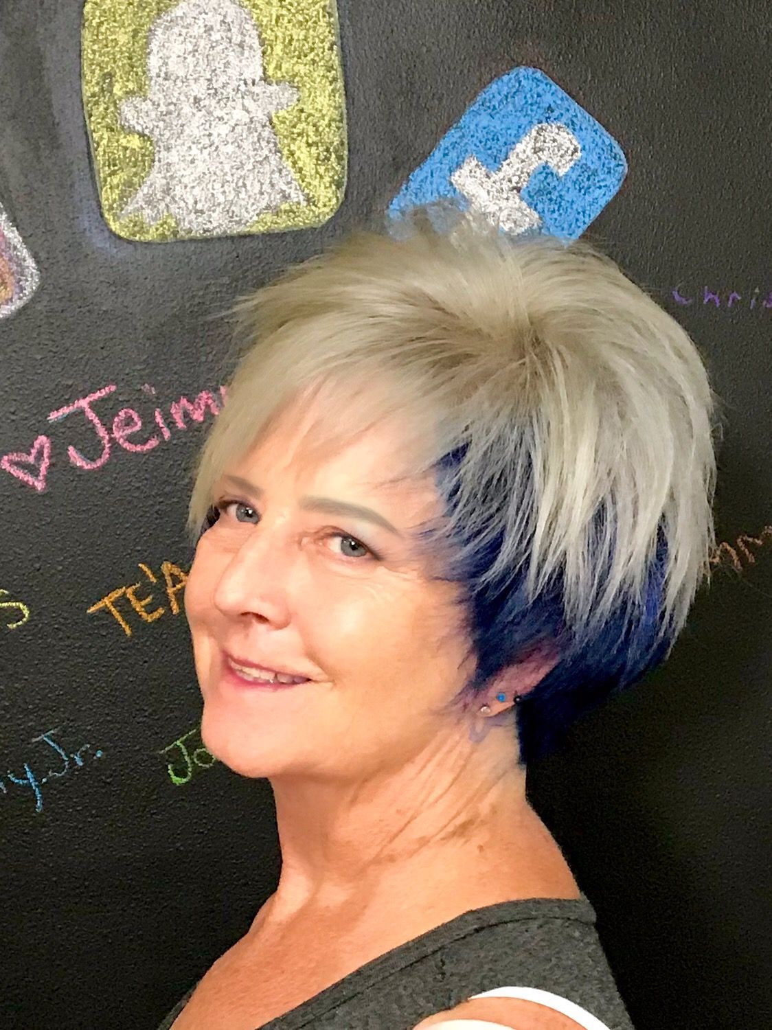 A short stacked bob with blond hair at the top and navy blue underneath
