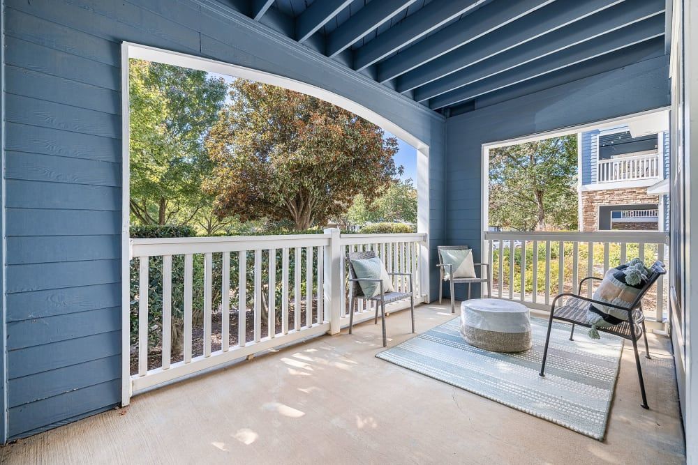 a balcony with chairs and a table on it at Marquis on Edwards Mill in Raleigh, NC.