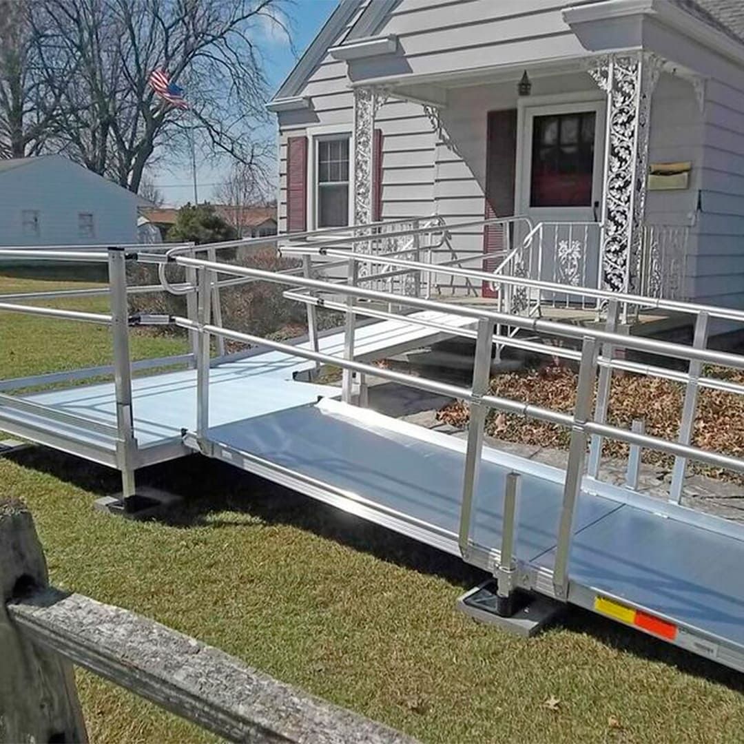 A handicap ramp is leading to the front of a house.