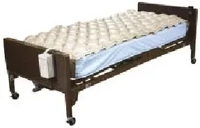 A hospital bed with a mattress and an air mattress on it.