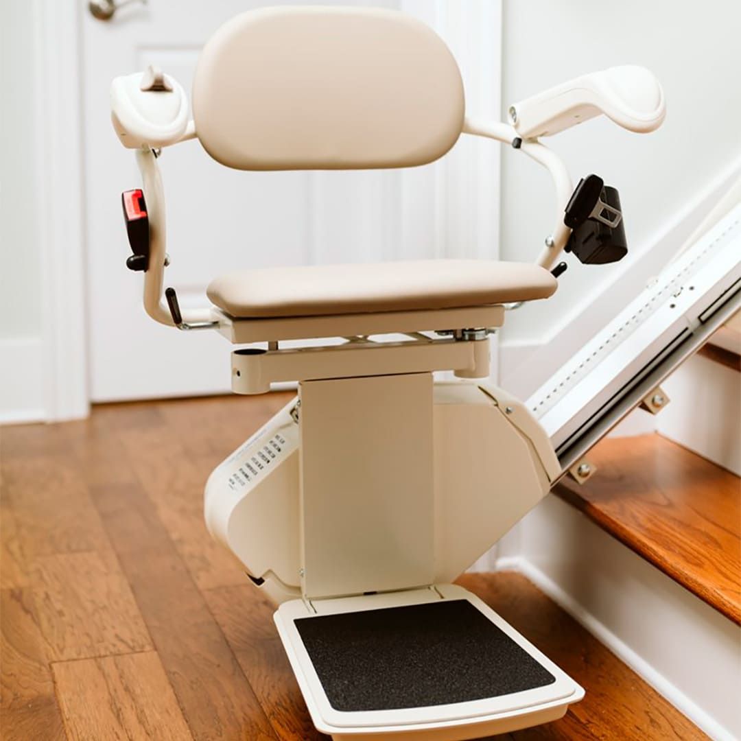 A white stair lift is sitting on a wooden floor