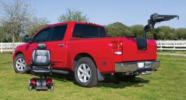 A red truck with a mobility chair in the back.