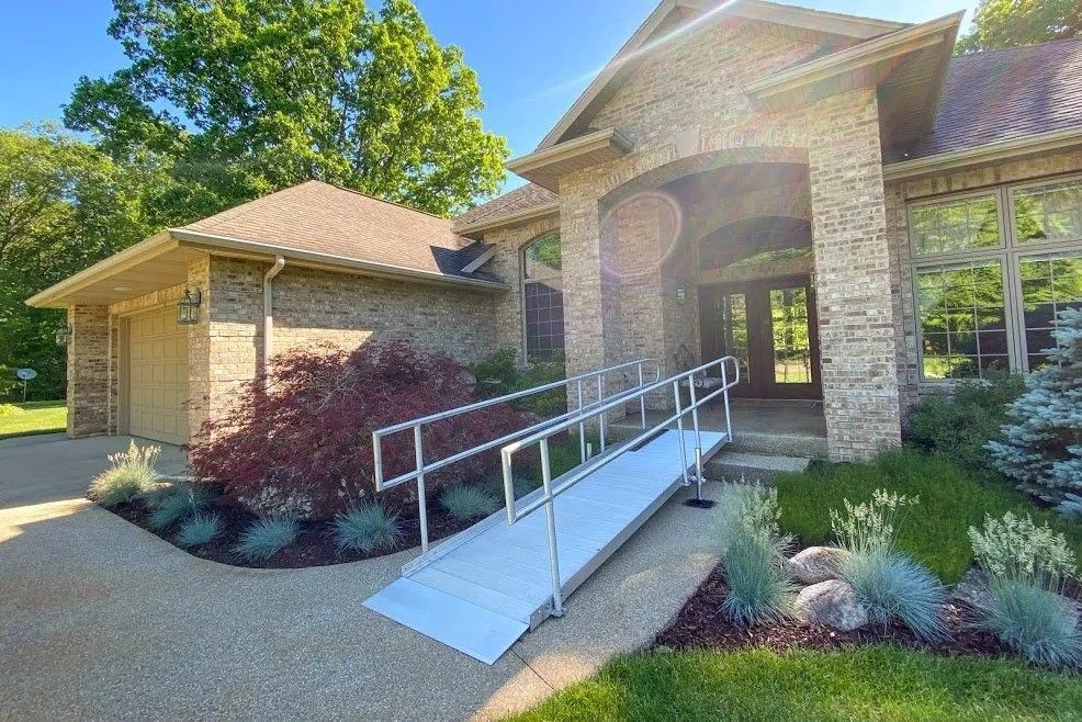 A house with a portable ramp for wheelchairs in front of it.