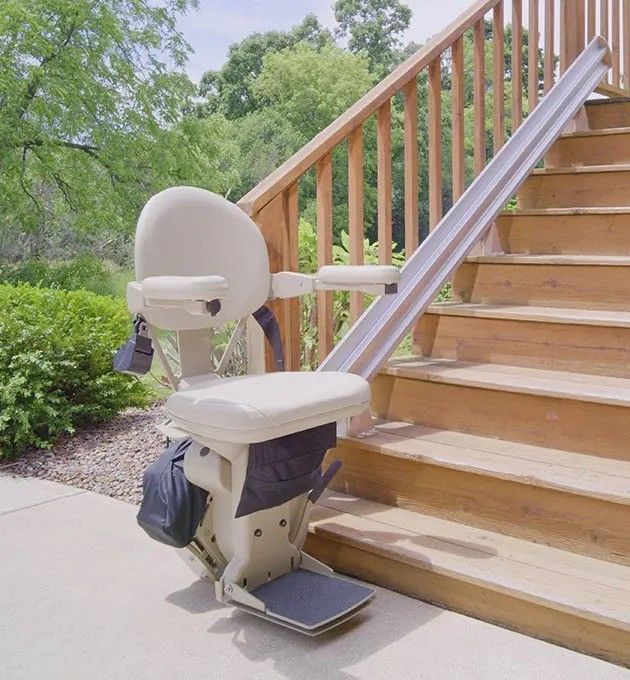 A stair lift sits on the side of a wooden staircase