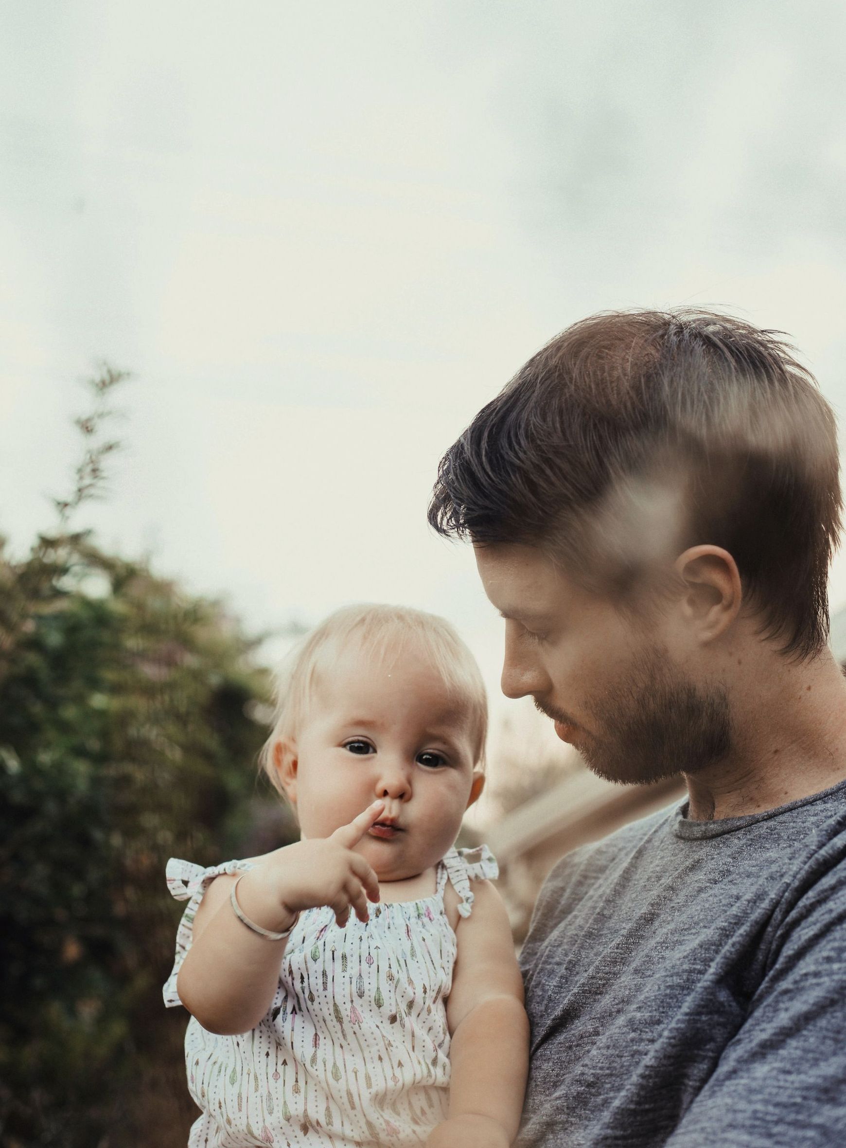 A man is holding a baby girl in his arms.