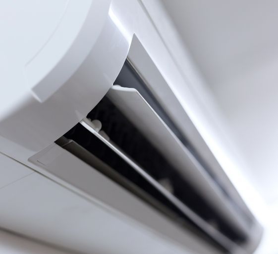 Close-up of a white wall-mounted air vent with dark interior slats