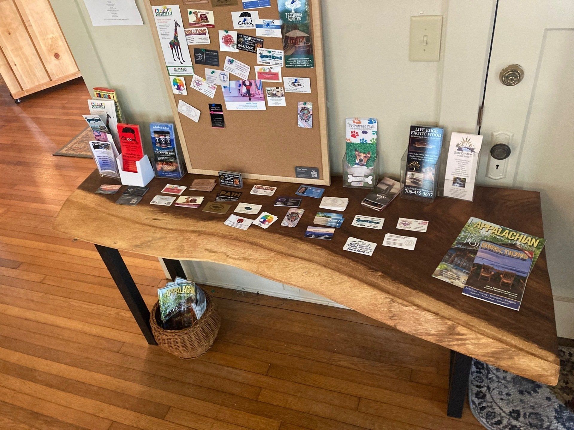 A wooden table with a cork board and brochures on it.