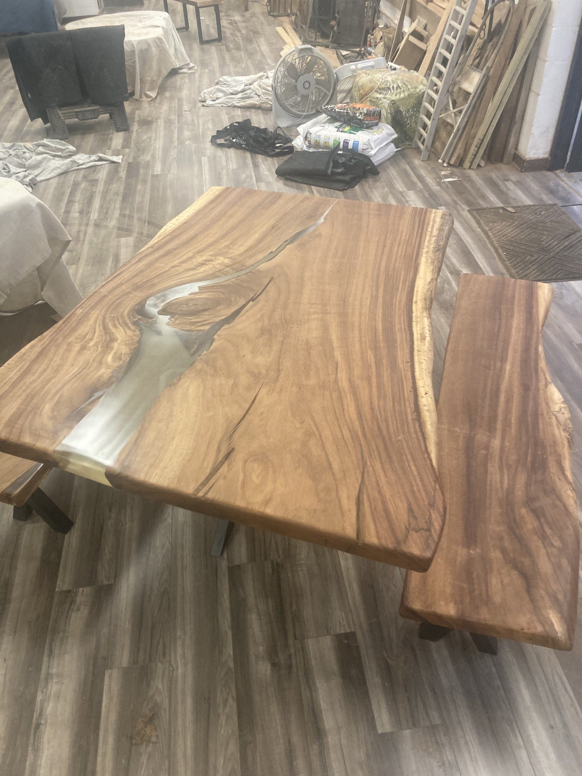 A wooden table and bench are sitting on a wooden floor in a room.