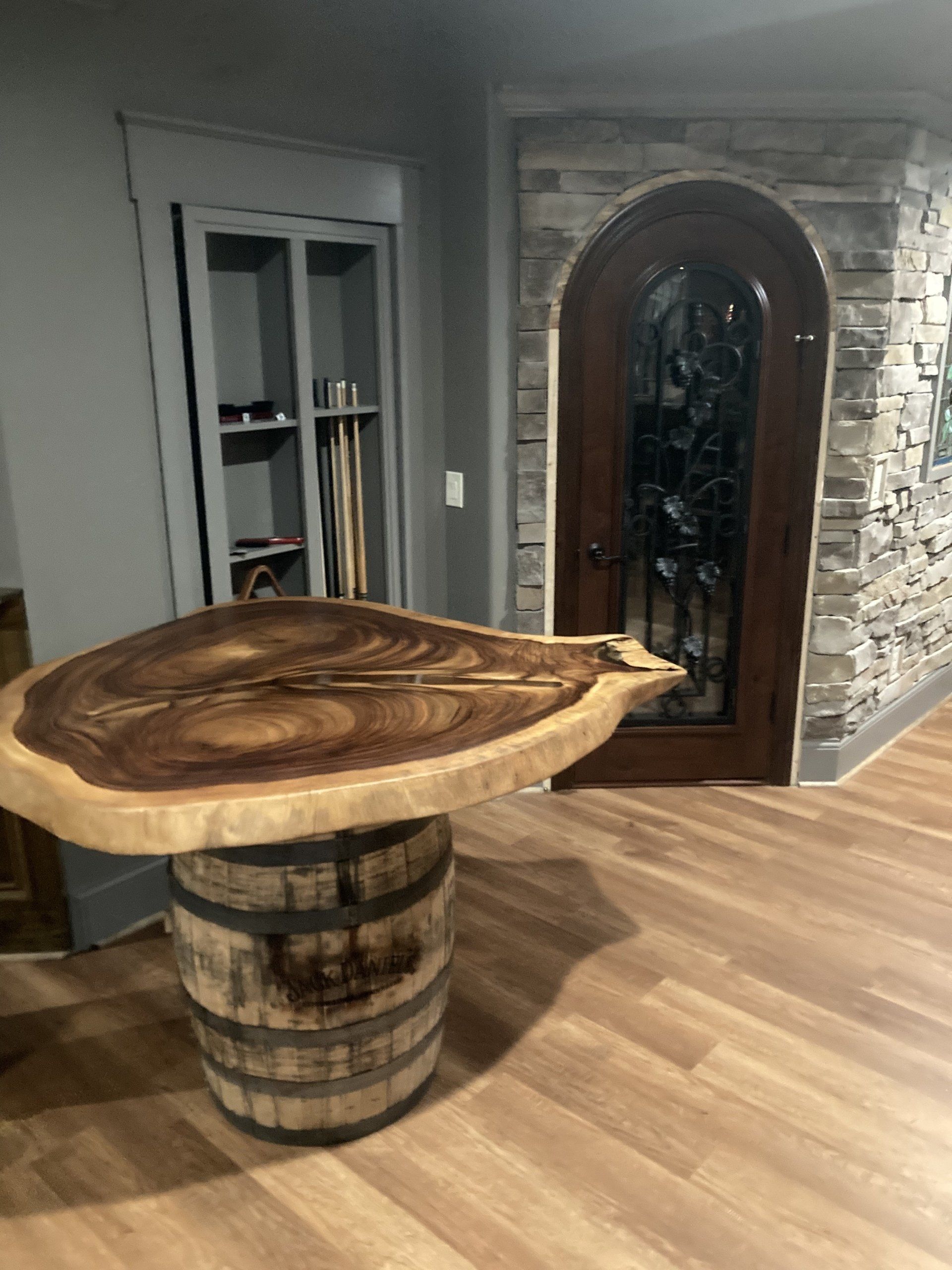A wooden table is sitting on top of a wooden barrel in a room.