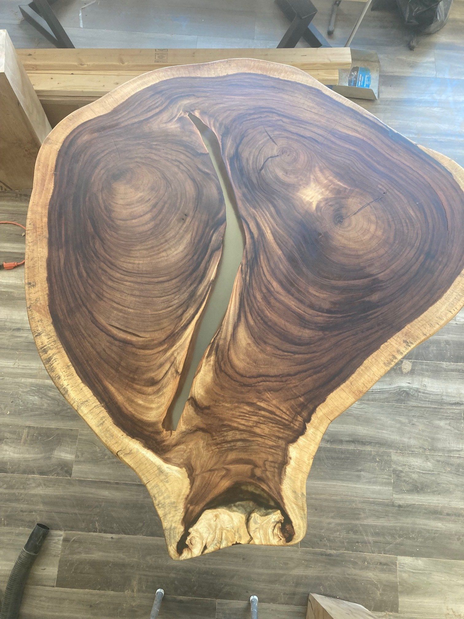 A large piece of wood with a hole in it is sitting on a wooden floor.