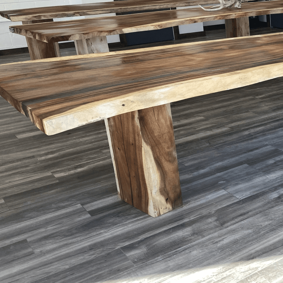 A row of wooden benches sitting next to each other on a wooden floor.