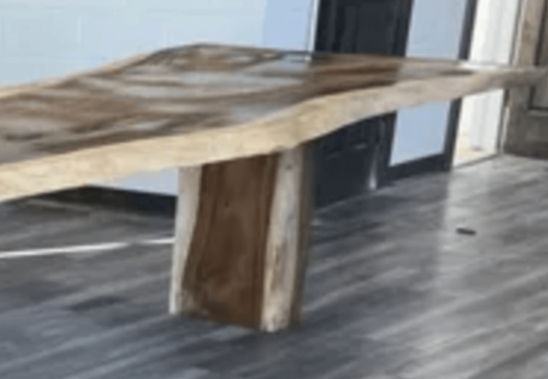 A wooden table is sitting on a wooden floor in a room.