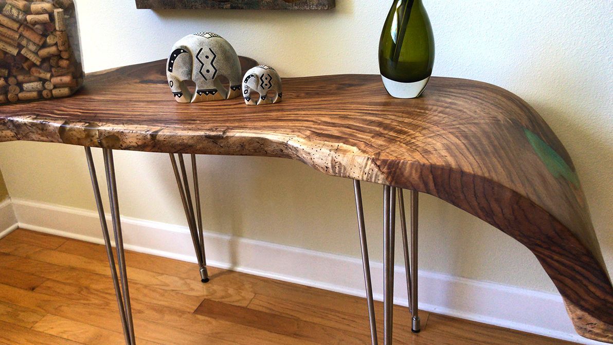 A wooden table with a vase and elephant figurines on it.