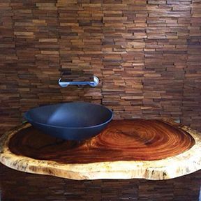 A black sink is sitting on top of a wooden counter.