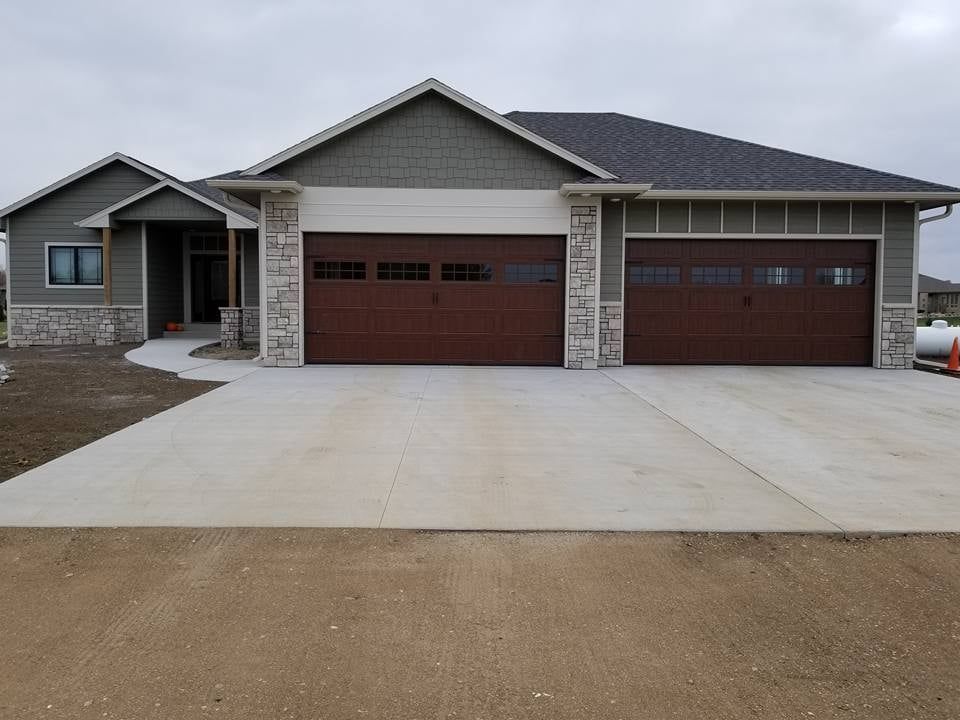 Single-story house with a three-car garage and wide concrete driveway.