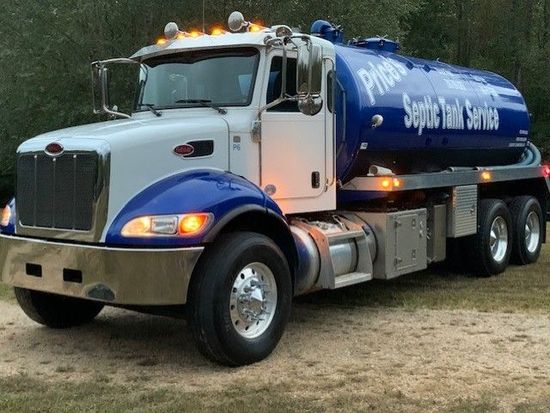 Blue and white septic tank truck parked outdoors with 