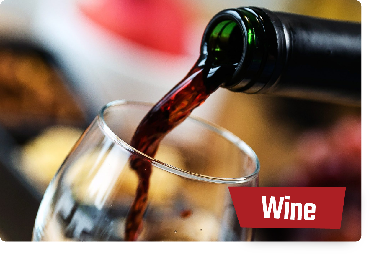 Wine being poured from a bottle into a tilted glass, with a red “Wine” label.