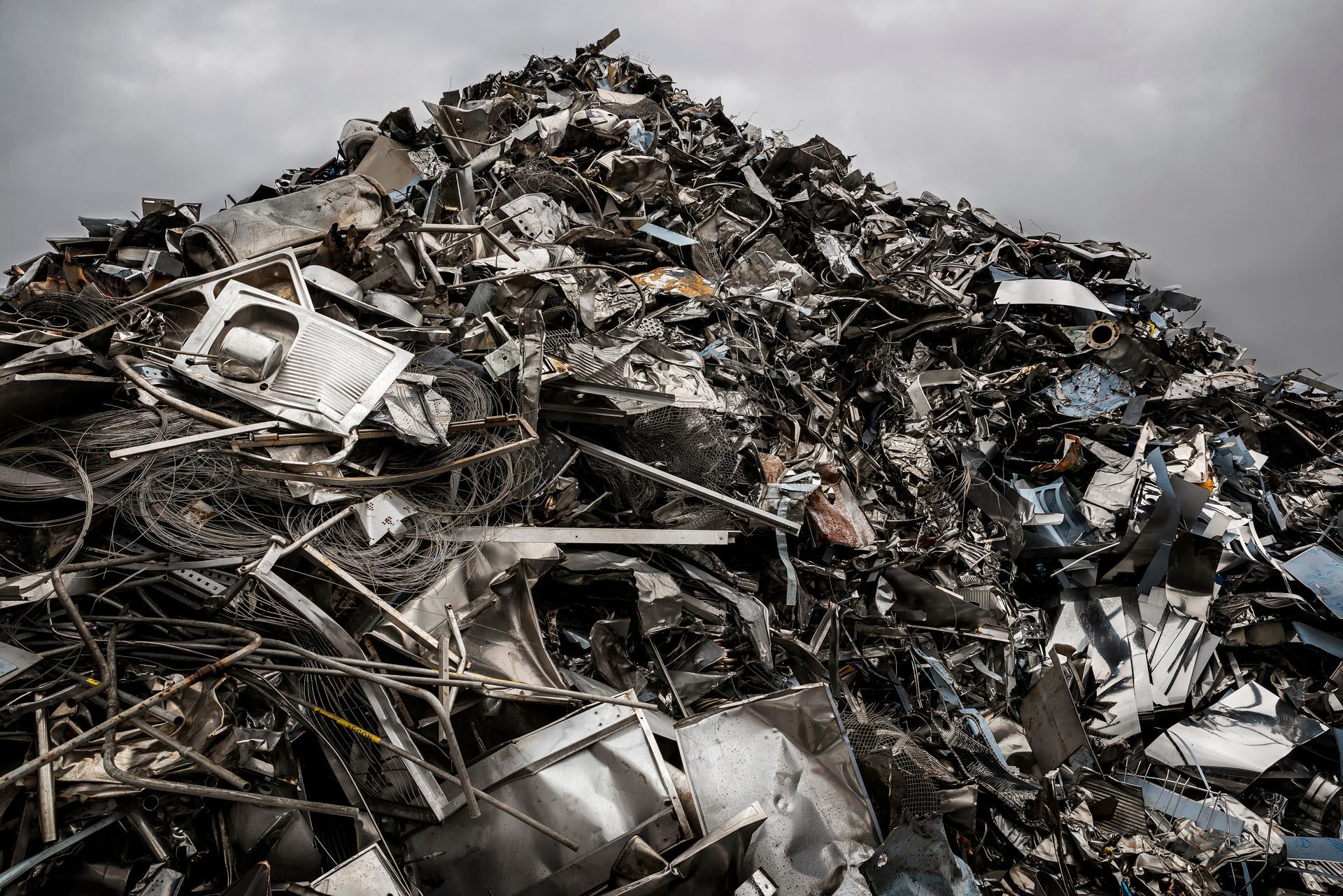 Towering mountain of steel scrap, stacked high and ready for recycling operations. Towering mountain of steel scrap, stacked high and ready for recycling operations.