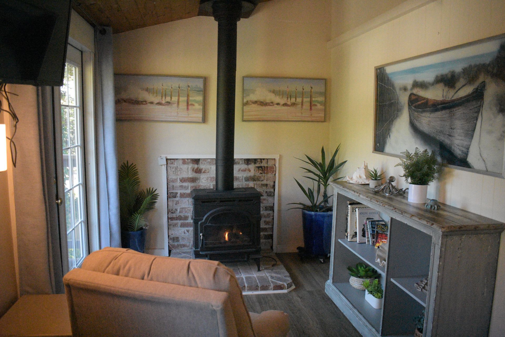 Cozy bedroom with bed, fireplace, armchair, and open doorway to a bathroom. Beige and white tones.