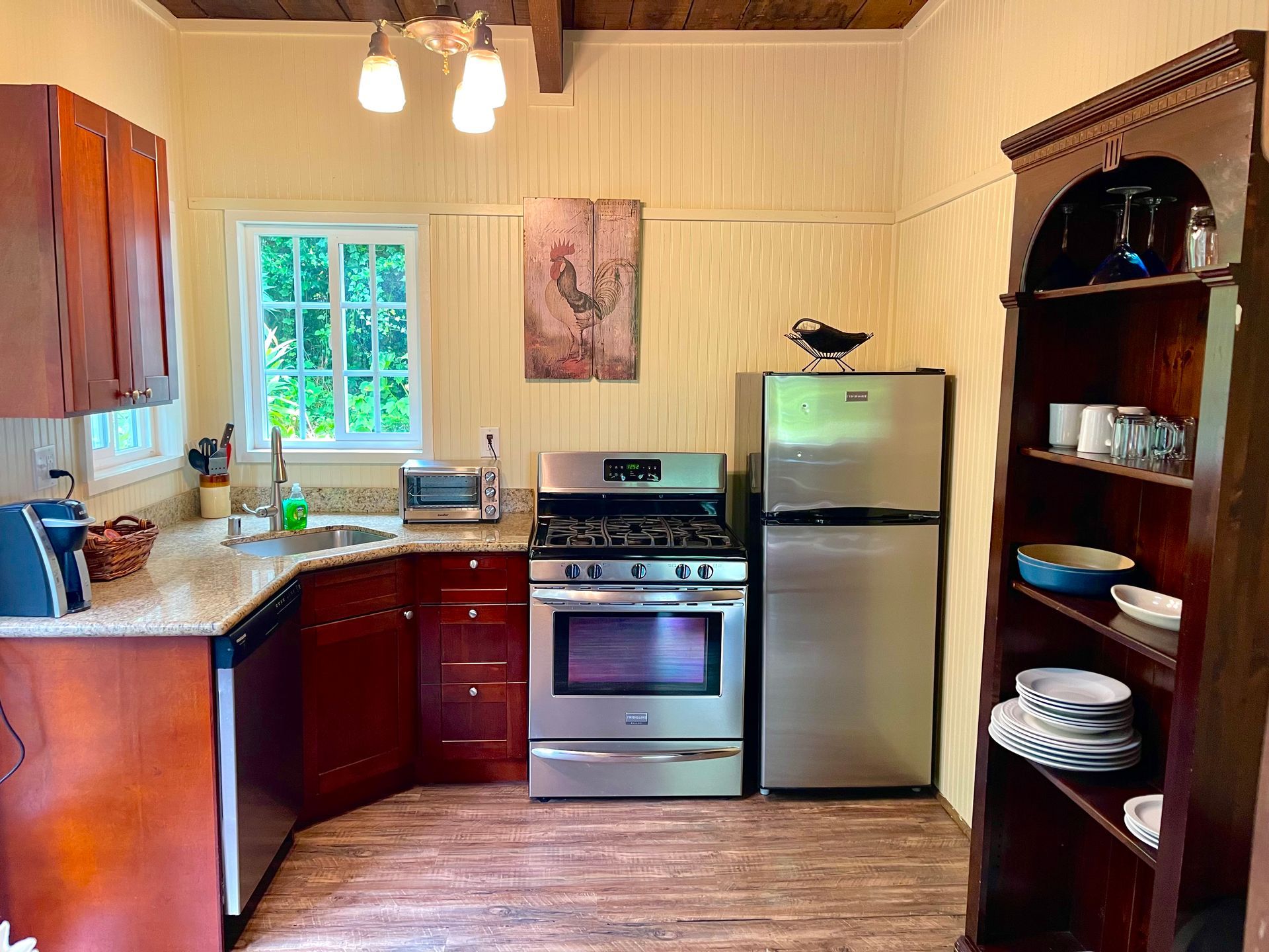 Kitchen with wooden cabinets, stainless steel appliances, and a wooden table. Door leads outside.