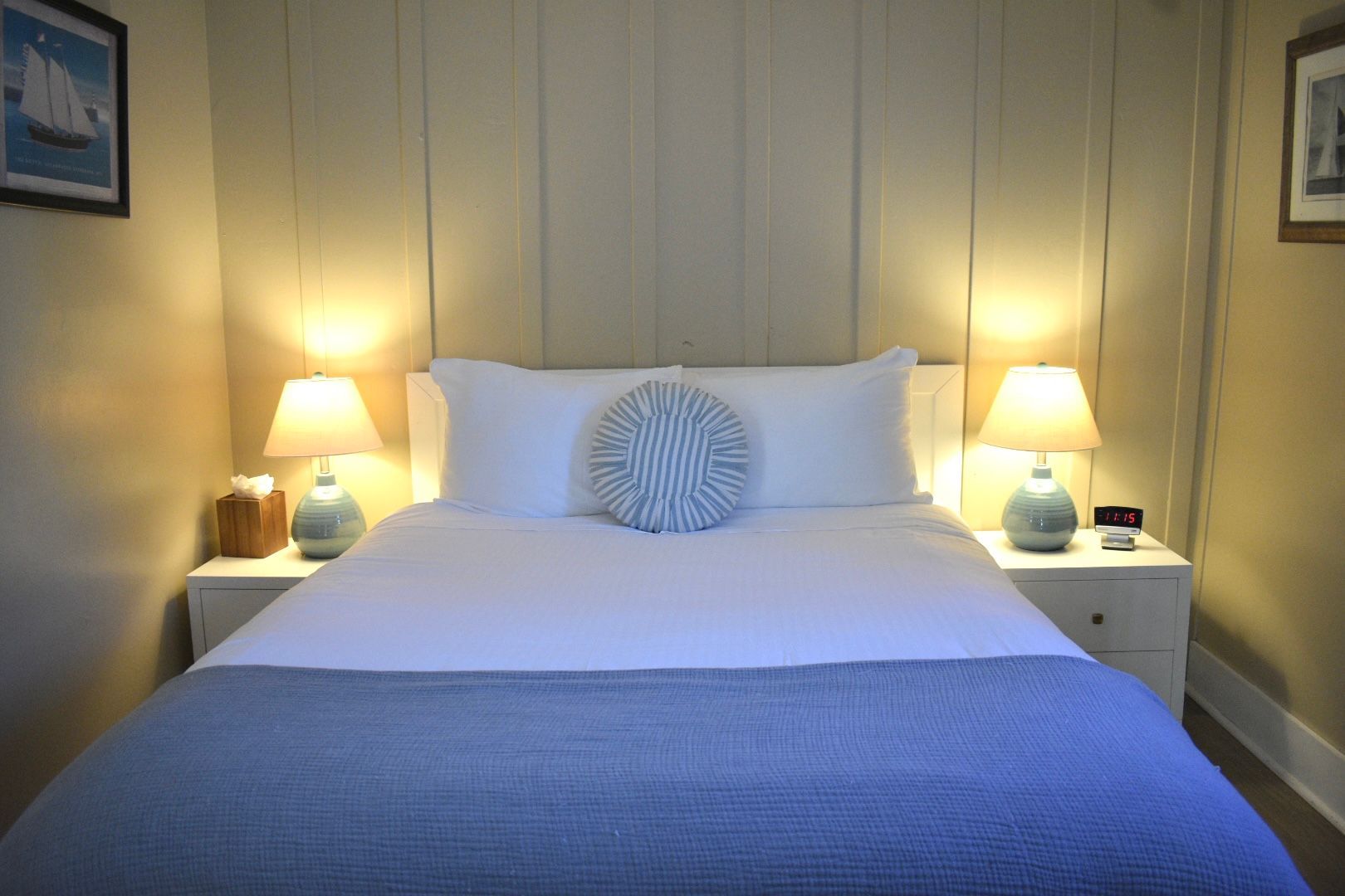 Bedroom with bed, nightstands, and window with blue curtains; red patterned carpet.