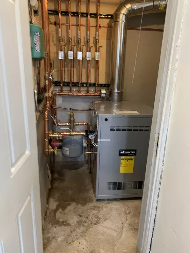A room with a heater and pipes in it.