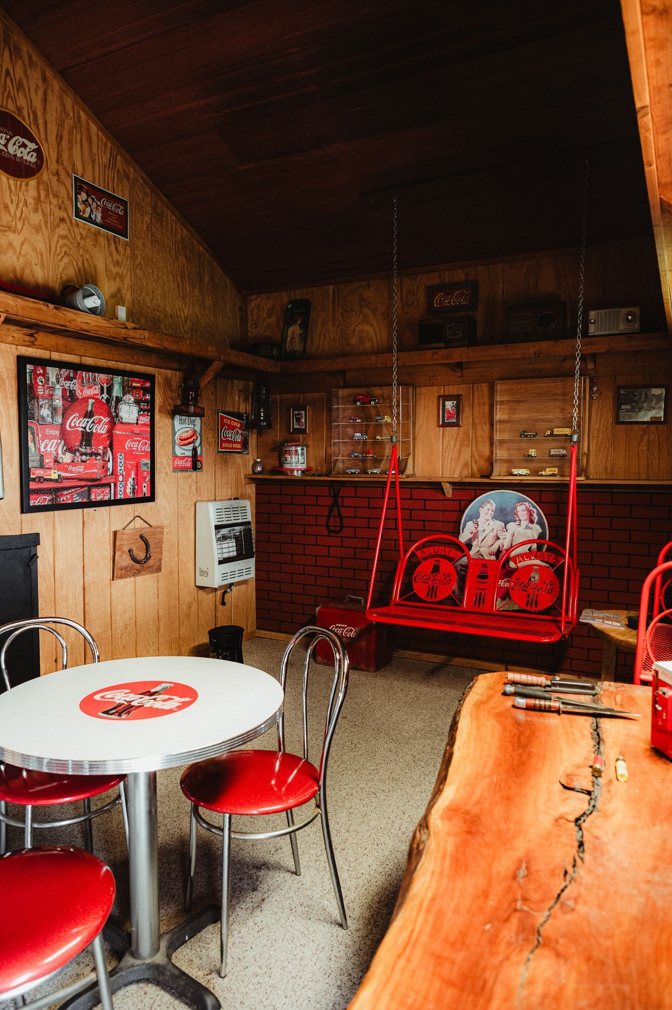 A man cave with a bar , chairs , a television , and bottles of liquor.