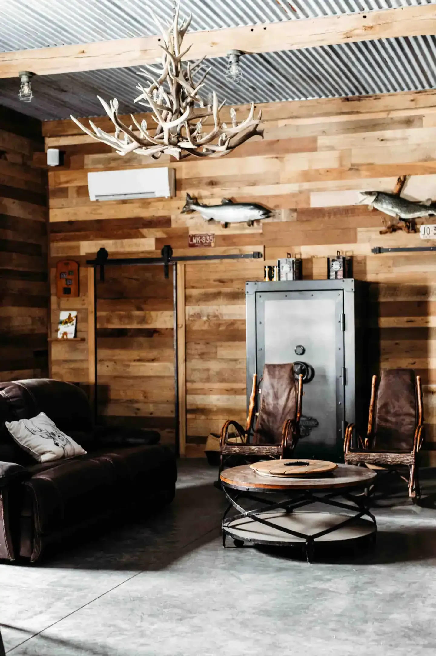 A living room with a couch , chairs , a table and a safe.