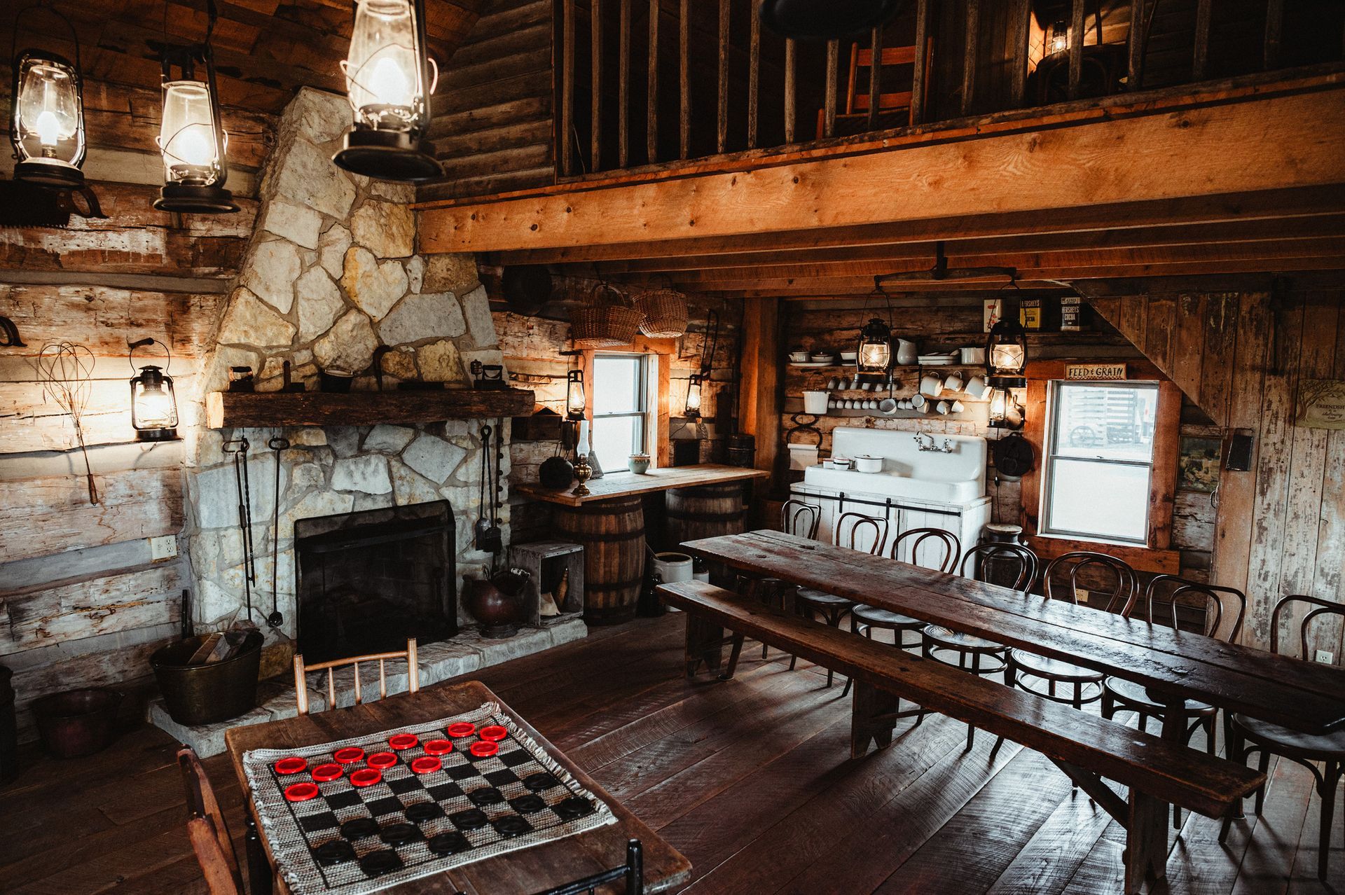 A large room with a deer head on the wall and a bar.