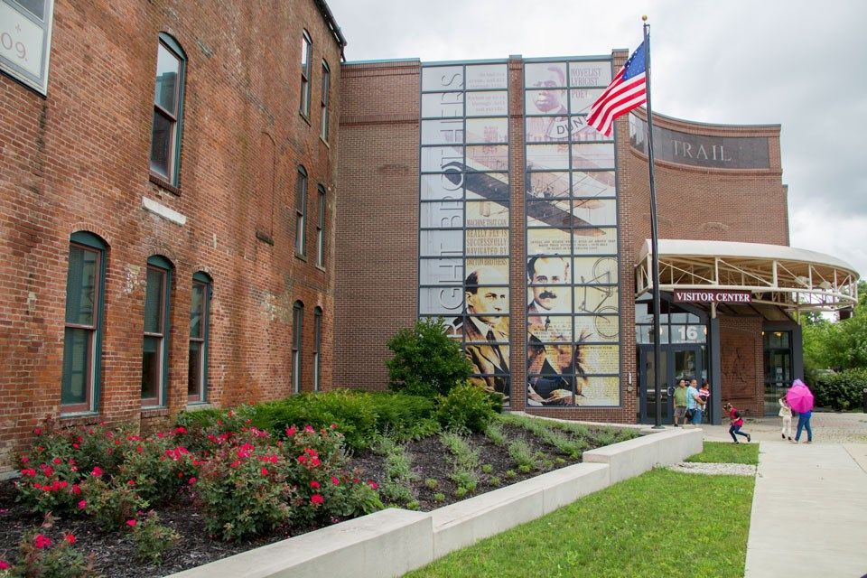 A large brick building with an american flag flying in front of it.