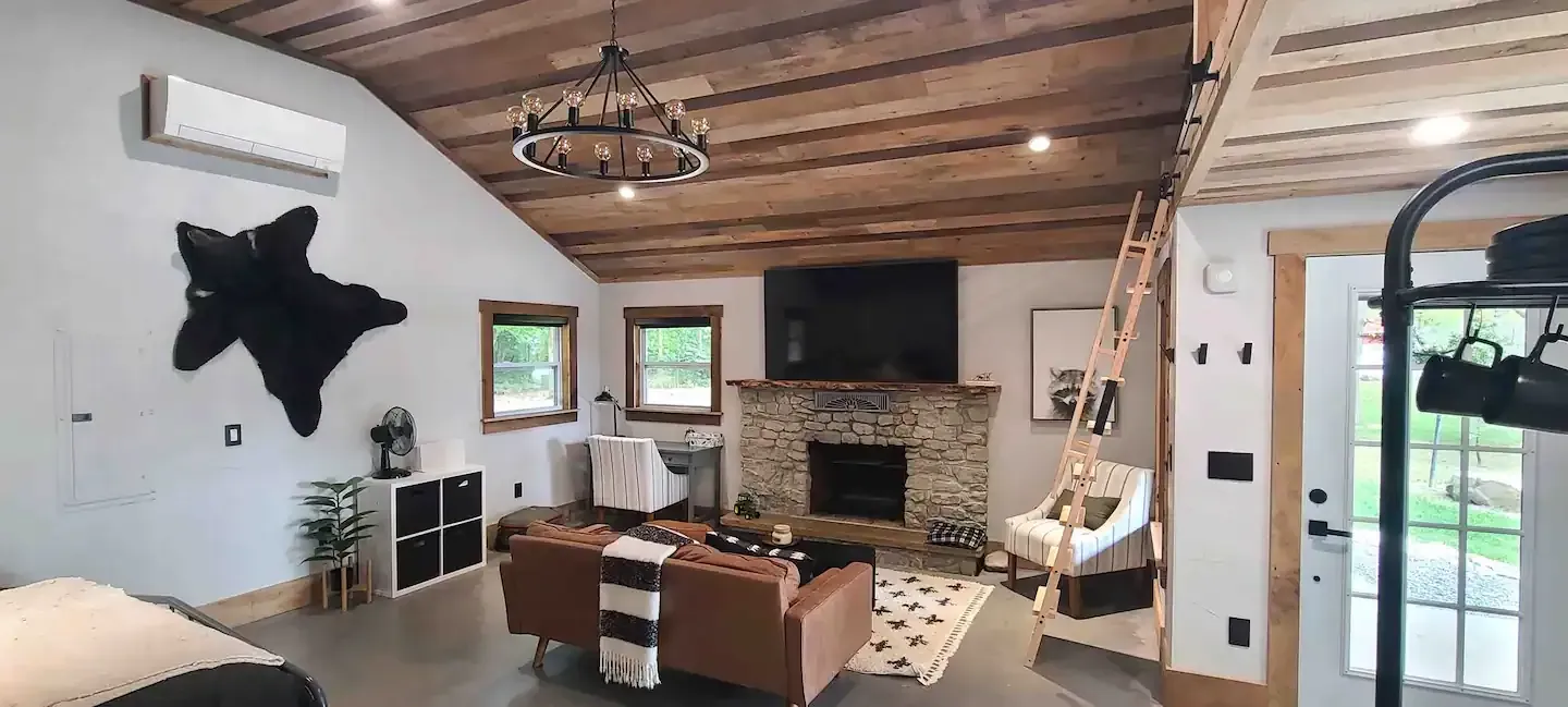 A living room with a fireplace , couch , chair and television.
