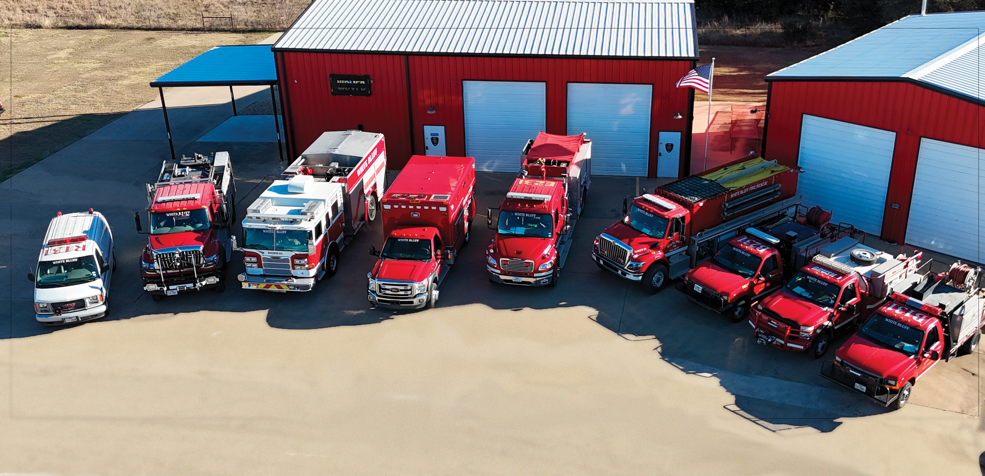 A group of firefighters are posing for a picture in front of a fire truck.