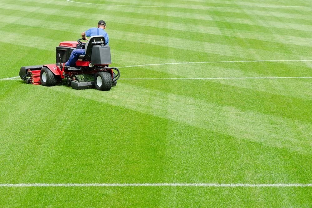 A Man is Riding a Lawn Mower on a Soccer Field — 4WD Slashing & Large Area Mowing In Mullumbimby, NSW