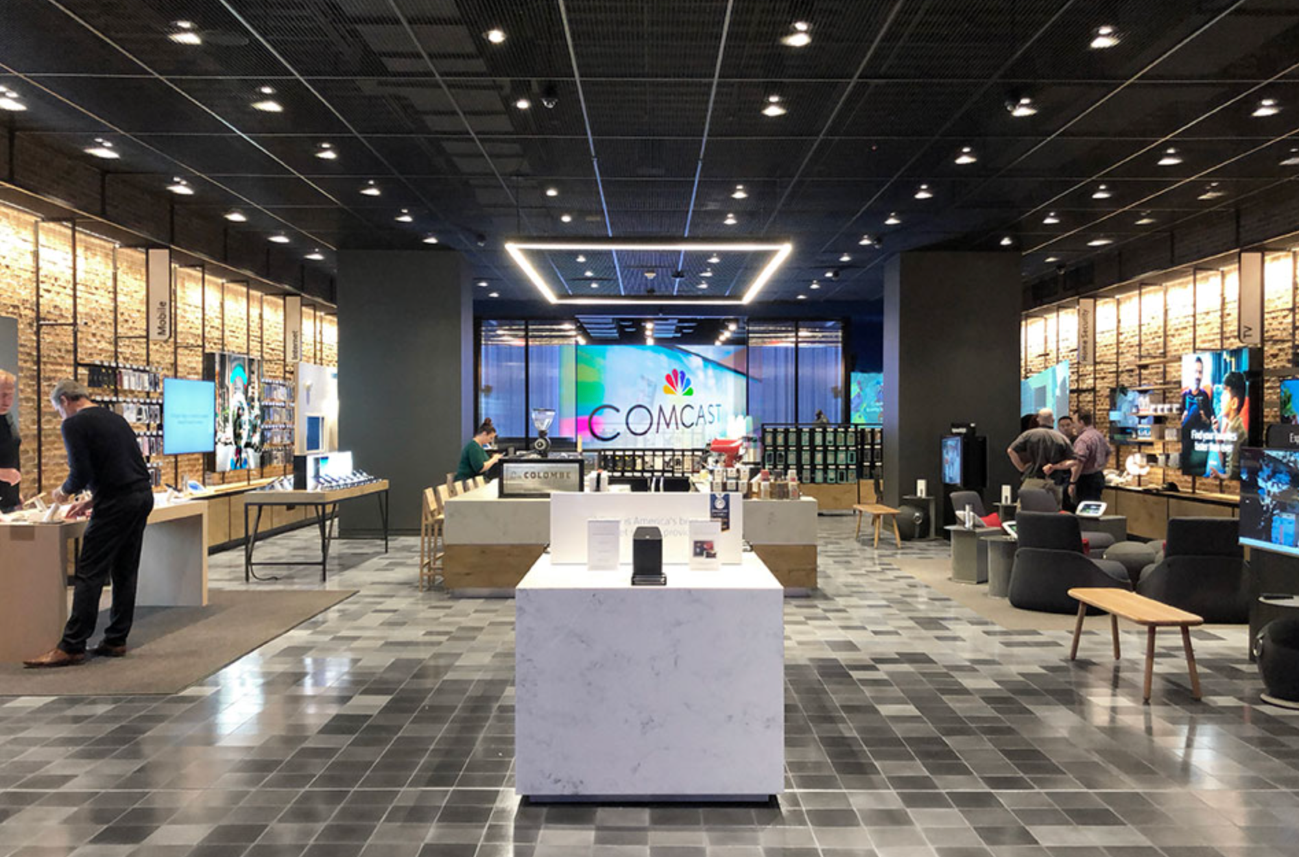 Modern electronics store interior with displays, tables, and customers browsing under bright ceiling lights