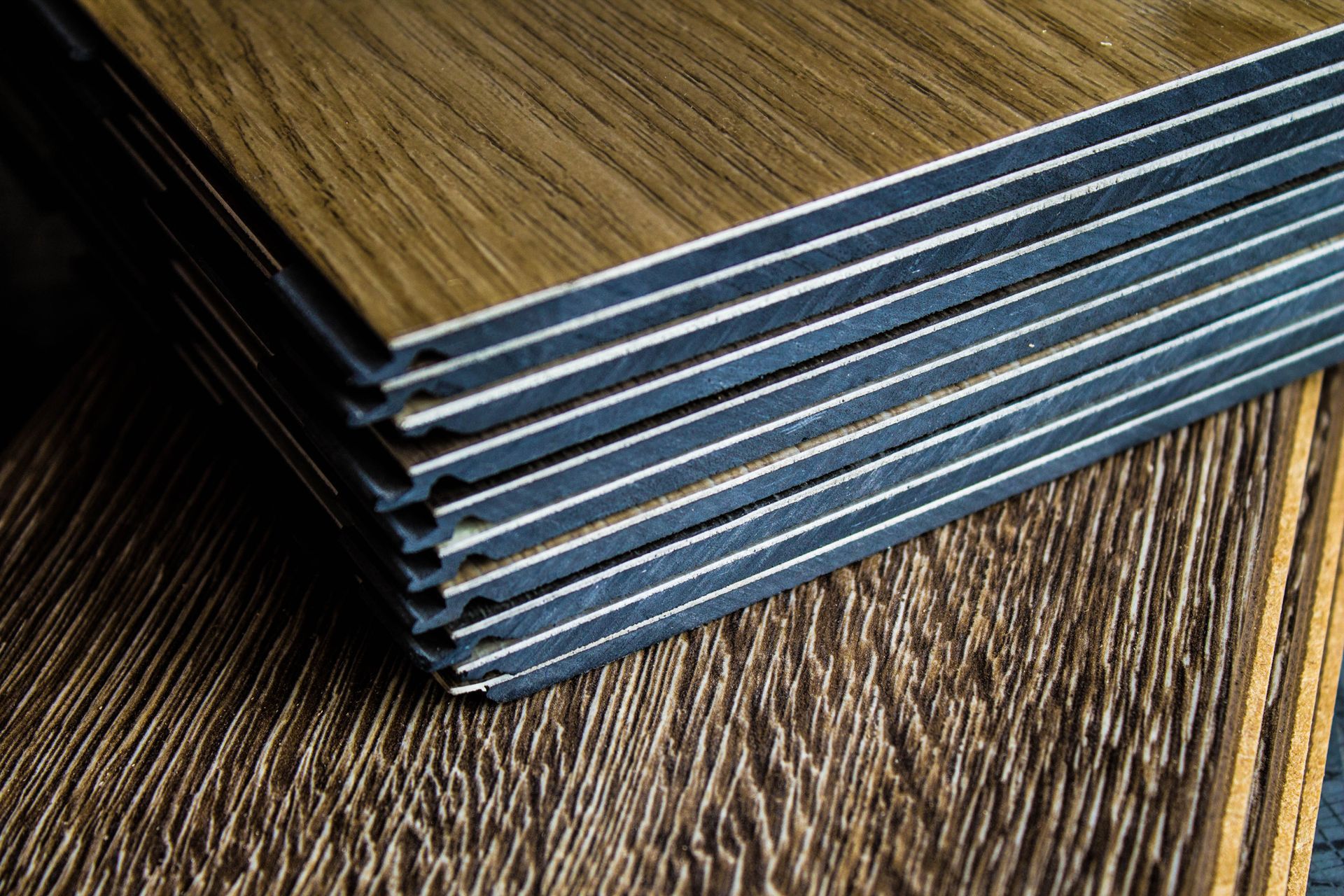 Stacked blue-edged metal sheets on a wood-grain surface