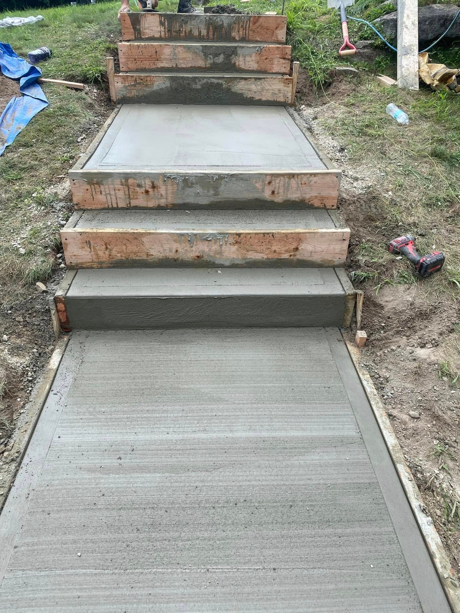 Concrete steps leading to a brick platform in a grassy outdoor yard