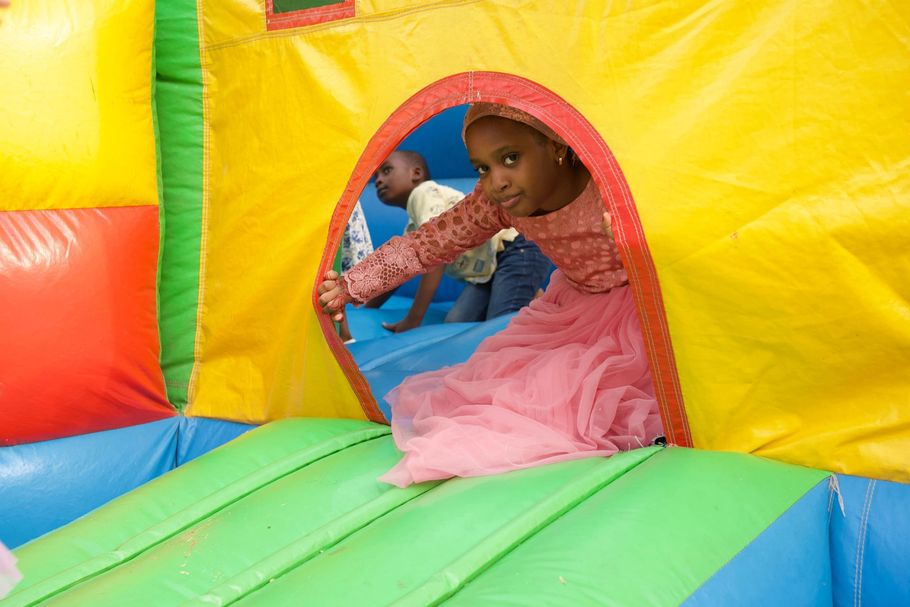 Child crawling through a colorful inflatable bounce house tunnel