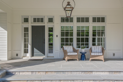 Front porch with white siding, double doors, hanging lantern, and two lounge chairs with a small table