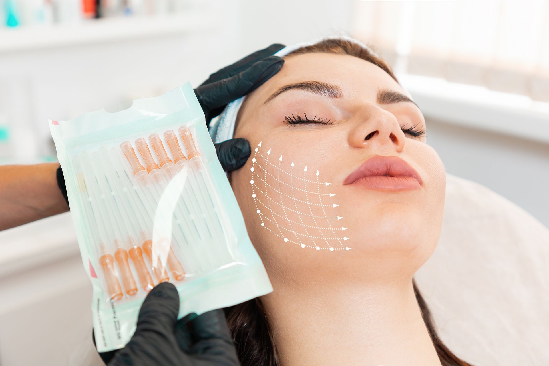 Woman receiving cosmetic procedure, with a diagram overlay on her face, holding packaged needles.
