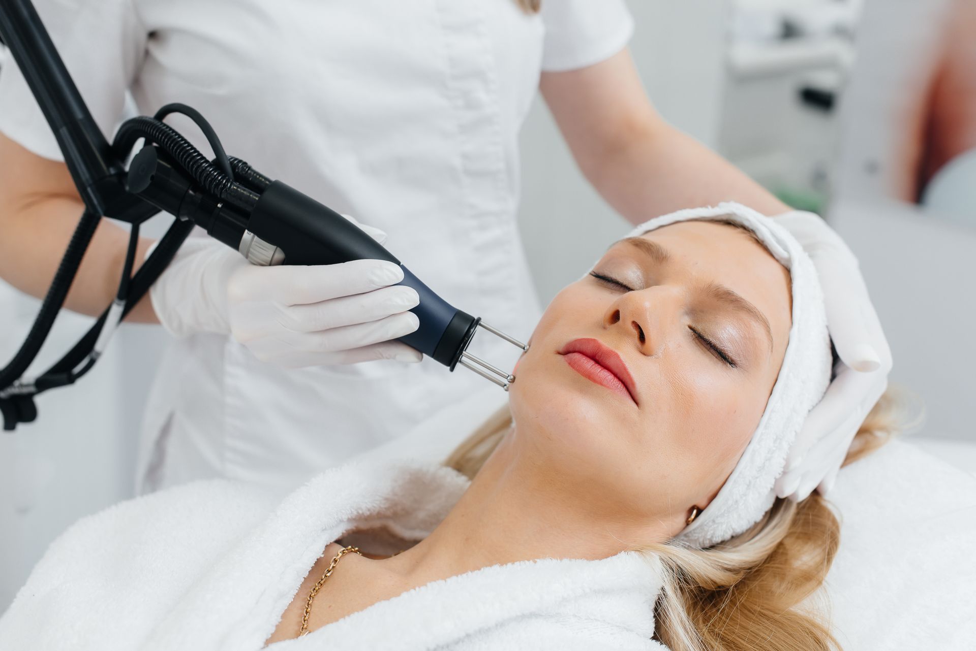 A woman is getting a laser treatment on her face.