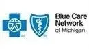 The blue care network of michigan logo is a blue cross and shield with a caduceus on it.
