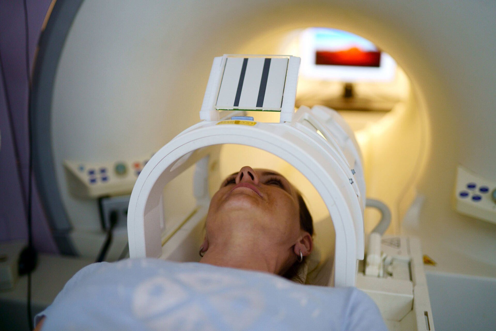 Women Receiving Scan Inside Tube — Costa Mesa, CA — Affiliated Medical Evaluators, Inc. Patient lying on a medical scanner table during a brain imaging scan