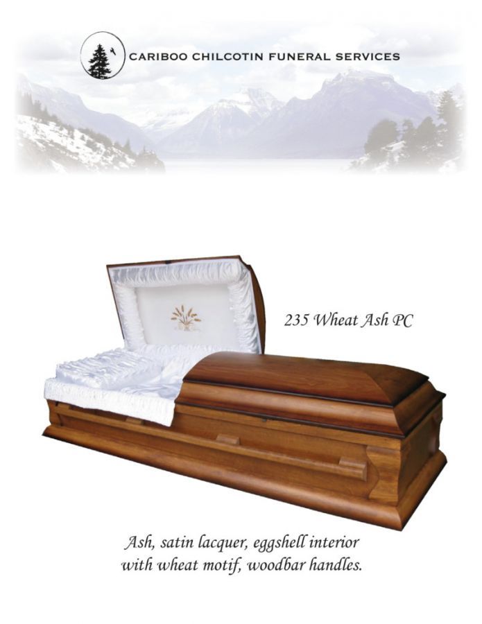 Wood coffin with white satin liner and wood handles, shown in a funeral service brochure.
