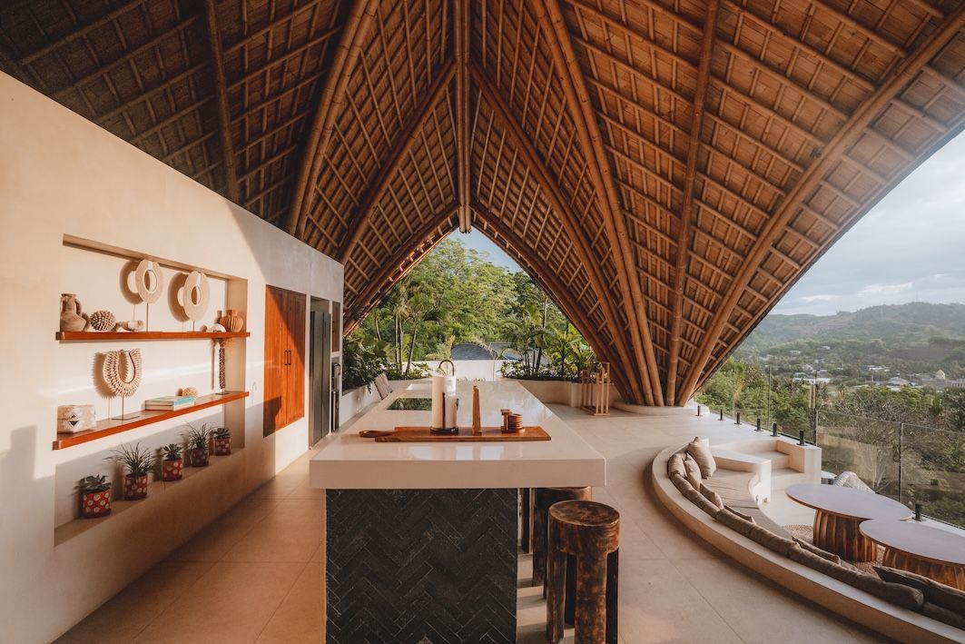 Open-air bamboo-roofed terrace with lounge seating and mountain valley view