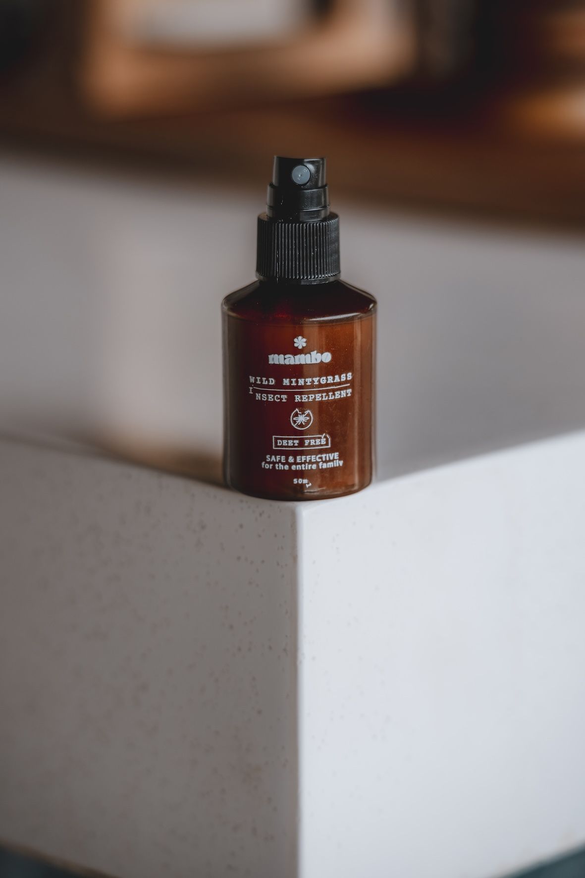 Brown pump bottle on a white surface against a blurred indoor background.